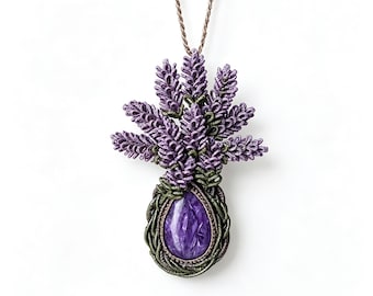 May include: A pendant necklace featuring a teardrop-shaped purple stone encased in dark green woven thread, topped with a cluster of textured purple lavender-like floral sprigs. The piece hangs from a thin, light brown twisted cord necklace.