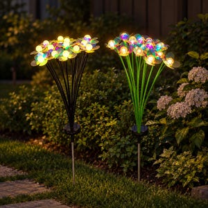 May include: Two solar-powered garden stake lights featuring multiple stems topped with glowing, spherical bulbs and translucent, iridescent petals. One unit has black stems, while the other has green stems, both with solar panels at the base.