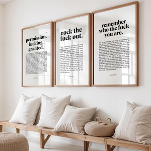 May include: Three framed wall art pieces with wooden frames. Each piece has a white background with black text. The text on the left reads "permission. fucking. granted.", the middle reads "rock the fuck out.", and the right reads "remember who the fuck you are."