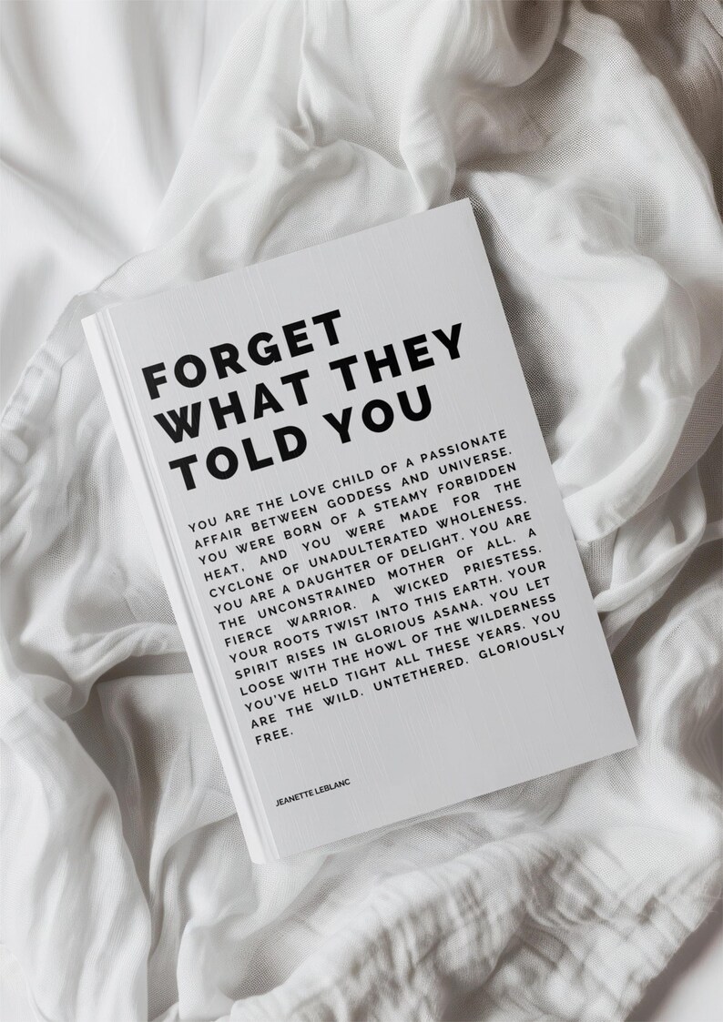 May include: A white book with the text "FORGET WHAT THEY TOLD YOU" in bold black letters. The book is lying on a white, textured fabric. The book's text continues with inspirational prose.