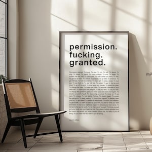 May include: A framed black and white print with the words "permission. fucking. granted." in bold font. The print is displayed in a room with a black chair with a woven back.