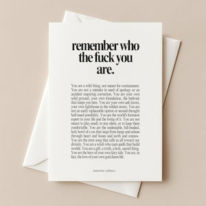 Puede incluir: Una tarjeta de felicitación blanca con texto en negro que dice, remember who the fuck you are, seguido de un párrafo de texto inspirador y el nombre Jeanette LeBlanc en la parte inferior. La tarjeta está sobre un sobre blanco a juego.