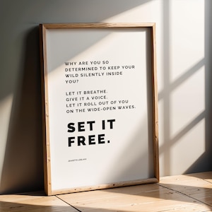 May include: A framed print with a light wood frame. The print features black text on a white background. The text includes the phrases "WHY ARE YOU SO DETERMINED TO KEEP YOUR WILD SILENTLY INSIDE YOU?" and "SET IT FREE."
