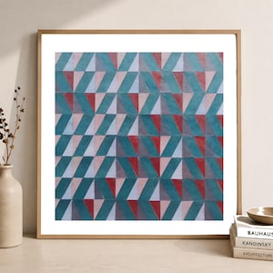 Könnte beinhalten: Ein quadratisches gerahmtes Wandbild mit einem sich wiederholenden geometrischen Muster aus Dreiecken und Parallelogrammen in den Farben Petrol, Hellrosa und Dunkelrot. Die Komposition erzeugt ein rhythmisches, ineinandergreifendes Design.