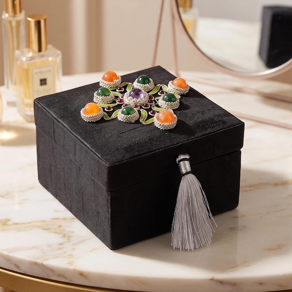 Hand-embroidered keepsake box with actual gemstones set into the lid — labor-intensive craft that looks like an heirloom from day one.