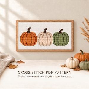 Könnte beinhalten: Ein rechteckiges gerahmtes Kreuzstichmuster mit drei Kürbissen in den Farben Orange, Creme und Grün. Der Text darunter lautet CROSS STITCH PDF PATTERN. Digital download. No physical item included. Das Design befindet sich auf weißem Stoff.
