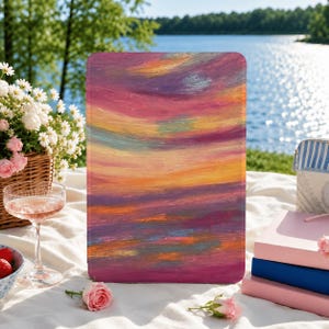 May include: A rectangular tablet case featuring an abstract painted design with horizontal brushstrokes in shades of magenta, orange, yellow, and soft blue, mimicking a sunset sky with a smooth, matte finish and rounded corners.