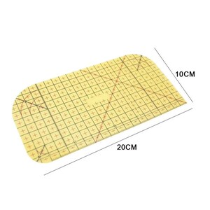 May include: A rectangular yellow quilting ruler with rounded corners, featuring a black grid pattern, crosshair markings, and diagonal lines. The ruler displays printed dimensions of 20 cm by 10 cm, providing precise measurements for sewing projects.