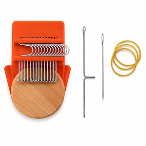 May include: A small orange plastic darning loom tool with a round wooden base, featuring multiple silver metal hooks. The set includes a long metal needle with a hook, a straight metal needle, and three yellow rubber bands for securing fabric.