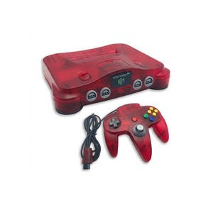Könnte beinhalten: Eine durchscheinend rote Nintendo 64 Videospielkonsole mit einem passenden kabelgebundenen Controller. Die Konsole zeigt das Nintendo 64 Logo auf der Vorderseite, vier Controller-Anschlüsse und einen Modulschacht. Der Controller verfügt über einen zentralen Analogstick, ein Steuerkreuz und mehrfarbige Aktionstasten.