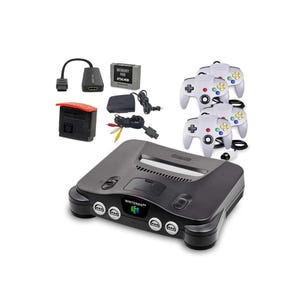 Puede incluir: Una consola de videojuegos Nintendo 64 negra con tres mandos grises, un pack de memoria de 256KB, un convertidor HDMI, una fuente de alimentación y un cable AV. La consola tiene el logo de Nintendo 64 al frente, cuatro puertos y ranura.