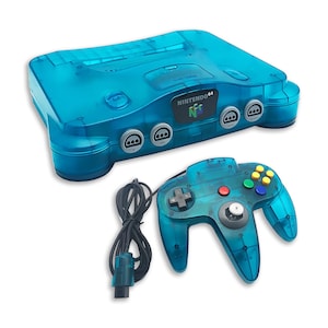 Könnte beinhalten: Eine durchscheinend blaue Nintendo 64 Videospielkonsole und ein passender kabelgebundener Controller. Die Konsole zeigt das Nintendo 64 Logo auf der Vorderseite, während der Controller einen grauen Analogstick, ein Steuerkreuz und mehrfarbige Tasten besitzt.