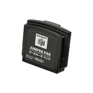 Może przedstawiać: Czarny dodatek rozszerzający pamięć Jumper Pak do konsoli Nintendo 64. Na przedniej etykiecie znajduje się logo Nintendo 64, napis JUMPER PAK, japońskie znaki, numer modelu NUS-A-TA G744782 oraz nazwa marki Nintendo w białym kolorze.
