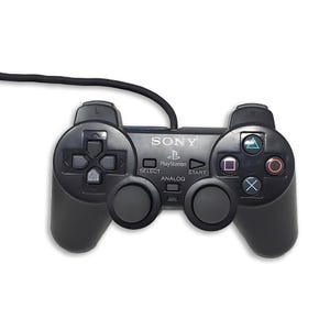 Może przedstawiać: Czarny przewodowy kontroler do gier Sony PlayStation z padem kierunkowym, dwoma analogowymi drążkami, czterema przyciskami akcji z symbolami trójkąta, koła, krzyżyka i kwadratu oraz przyciskami Select, Start i Analog.
