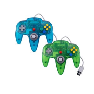 May include: Two wired video game controllers with translucent shells in bright blue and green. Each controller features a central grey analogue stick, a directional pad, four yellow buttons, two green and blue buttons, and a grey connector cable.