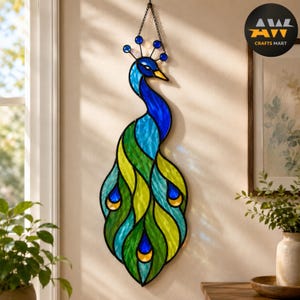 May include: A stained glass peacock wall hanging featuring vibrant blue, green, and yellow glass segments outlined in black metal. The design includes a long neck, a crest with blue glass beads, and a tail with stylised eye-shaped patterns.