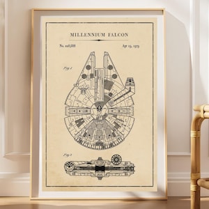 Könnte beinhalten: Ein gerahmter Kunstdruck mit einer technischen Patent-Illustration des Millennium Falcon. Der beige Hintergrund zeigt schwarze Strichzeichnungen des Raumschiffs aus zwei Winkeln, beschriftet mit Fig 1 und Fig 2, sowie dem Text Millennium Falcon, No. 228,688, und Apr 19, 1979.