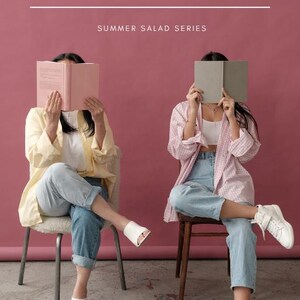 May include: A digital graphic titled VEGGIE HACKS SUMMER SALAD SERIES EBOOK/COURSE THE ROOTED & HOLISTIC COLLECTIVE. Two individuals sit on chairs, each holding a book over their face. One wears a yellow shirt, white top, jeans, and white mules. The other wears a pink plaid shirt, white top, jeans, and white sneakers.
