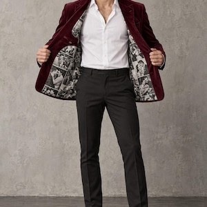 Peut inclure: Un blazer en velours bordeaux porté avec une chemise blanche boutonnée et un pantalon noir. Le blazer présente une doublure intérieure personnalisée imprimée d'un collage de photos en noir et blanc. Le logo Noir and Needle est visible.