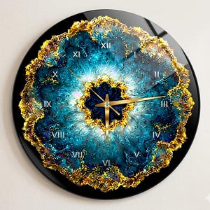 Può includere: Un orologio da parete circolare con un vivace motivo astratto blu e bianco che ricorda una geode, circondato da un bordo dorato testurizzato. Il quadrante mostra numeri romani da I a XII in bianco, con lancette color oro per ore e minuti.