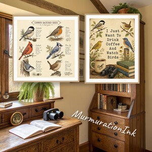 Two birdwatching prints framed in a cosy wooden study: a common backyard birds field guide and an I just want to drink coffee and watch birds print above a writing desk with binoculars.