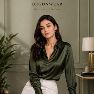 Könnte beinhalten: Ein langärmeliges, olivgrünes Satinhemd mit Knopfleiste und eine weiße Hose. Das Bild enthält den Text ORGONWEAR MEN'S, WOMEN'S CLOTHING oben, zentriert unter einem kreisförmigen Logo mit einem Kronensymbol über dem Buchstaben O.