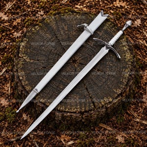 Puede incluir: Una espada de metal plateado con un mango envuelto en blanco y una vaina blanca a juego. La espada presenta una hoja puntiaguda, una guarda con detalles oscuros y un pomo. El texto VELKOR FORGE se repite en el fondo de la imagen.