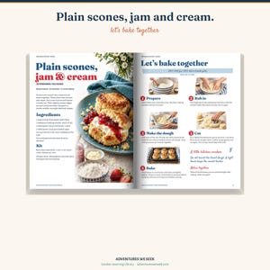 May include: An open cookbook page titled Plain scones, jam and cream, featuring a recipe with ingredients, a kit list, and step-by-step instructions. The left page shows a photograph of two scones topped with jam and cream on a blue plate.