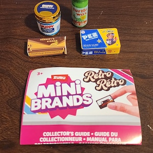 May include: A collection of miniature toy items including a Skippy peanut butter jar, a green Turtle Wax bottle, a Hershey's Kisses box, a Pez candy tin, and a Zuru Mini Brands Retro collector's guide featuring text and a graphic of a cassette tape.