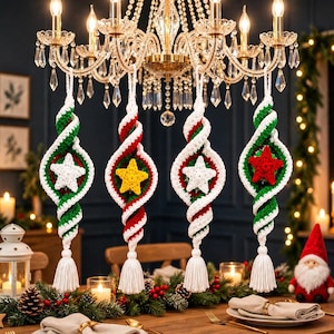 May include: Four hanging crochet ornaments featuring a spiral design in red, white, and green yarn. Each ornament displays a central five-pointed star in white, yellow, or red, and terminates in a white yarn tassel at the bottom for decoration.