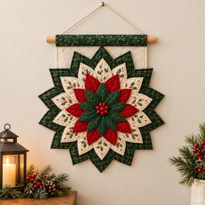 Könnte beinhalten: Ein gesteppter Wandbehang aus Stoff mit einem mehrschichtigen Weihnachtsstern-Design aus roten, dunkelgrünen und cremefarbenen Blütenblättern. In der Mitte befinden sich kleine rote Beeren. Er hängt an einem Holzstab mit einem grünen Stoffbesatz mit Stechpalmenmuster.