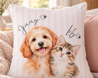 Puede incluir: Un cojín cuadrado con un patrón de rayas verticales en rosa claro y blanco. En el centro aparecen un cachorro dorado y un gatito atigrado marrón. El texto Jimmy y Lily está impreso en letra cursiva negra con iconos de corazón y huella.