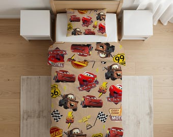 Può includere: Un set di biancheria da letto color marrone chiaro con un motivo ripetuto dei personaggi del film Cars, tra cui Saetta McQueen e Cricchetto, insieme a segnali della Route 66, bandiere a scacchi, fulmini e il numero 95 in rosso, giallo e marrone.