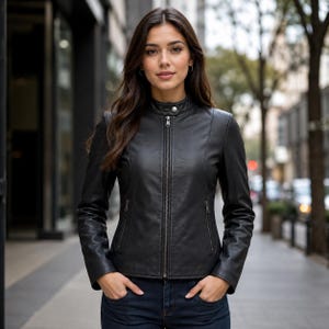 May include: A black leather jacket featuring a stand-up collar with a single snap button closure, a full-length front zipper, and two zippered side pockets. The jacket has long sleeves and a fitted silhouette, constructed from smooth black leather.