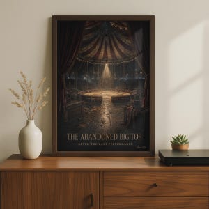 Könnte beinhalten: Ein gerahmter Kunstdruck, der das Innere eines leeren Zirkuszeltes mit roten Vorhängen, einer Manege und Lichterketten zeigt. Der Text lautet THE ABANDONED BIG TOP AFTER THE LAST PERFORMANCE. Das Bild befindet sich in einem dunkelbraunen Holzrahmen.