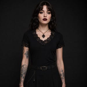 Camiseta gótica negra con cuello en V y encaje, manga corta, corte ajustado.