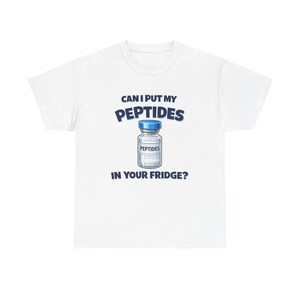 May include: A white short-sleeve t-shirt featuring a graphic of a small glass vial with a blue cap. The text "CAN I PUT MY PEPTIDES IN YOUR FRIDGE?" is printed in dark blue letters above and below the vial, with the word "PEPTIDES" on the vial label.