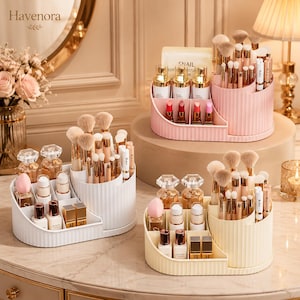 Puede incluir: Tres organizadores de cosméticos escalonados en blanco, rosa pastel y amarillo pálido. Cada uno presenta un exterior acanalado, una sección cilíndrica para brochas de maquillaje y compartimentos rectangulares para frascos, labiales y envases.