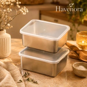 Pode incluir: Dois recipientes retangulares de aço inoxidável para armazenamento de alimentos empilhados verticalmente, cada um com uma tampa de plástico transparente de encaixe justo. Os recipientes têm um acabamento metálico liso e um design funcional e limpo.