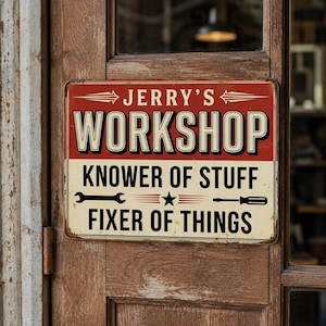 May include: A rectangular metal sign with a red top section and a cream bottom section. The text reads JERRY'S WORKSHOP, KNOWER OF STUFF, and FIXER OF THINGS. It features a black wrench and a screwdriver icon separated by a star in the center.