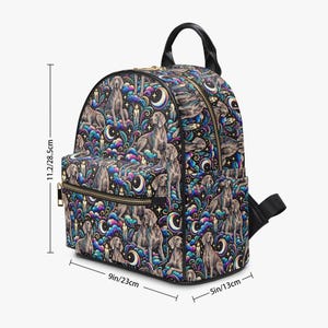 Puede incluir: Una mochila con un patrón de perros Weimaraner, lunas crecientes, velas y nubes coloridas en espiral. Tiene un bolsillo frontal con cremallera, correas negras y cremalleras doradas. Sus dimensiones son 28,5 cm de alto, 23 cm de ancho y 13 cm de fondo.