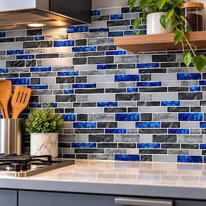 May include: A kitchen backsplash featuring a rectangular tile pattern in alternating shades of deep blue, charcoal gray marble, and metallic silver. The tiles are arranged in a staggered brick layout, creating a textured surface behind a stove.