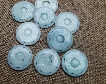May include: Eight jade green circular pendants with intricate designs. The pendants are carved with a circular pattern and have a smooth, polished finish.