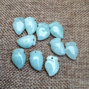 May include: Ten light blue jade pendants in the shape of leaves with a hole at the top for stringing.
