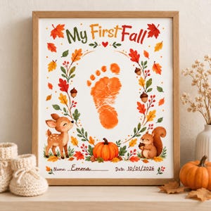 May include: A framed print titled My First Fall featuring a central orange baby footprint surrounded by a wreath of autumn leaves, acorns, a deer, and a squirrel. At the bottom, the text reads Name: Emma and Date: 10/01/2026 with a pumpkin.