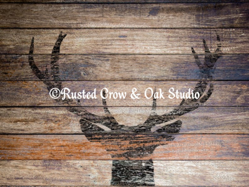Pu&ograve; includere: Uno sfondo in legno rustico con una silhouette di una testa di cervo in stencil. Lo stencil &egrave; dipinto di nero ed &egrave; centrato sul legno. Il testo "Rusted Crow & Oak Studio" &egrave; stampato in bianco nella parte inferiore dell'immagine.