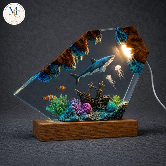 A hand-poured epoxy resin lamp with a shark suspended inside glowing wood — like a tiny ocean frozen in light.