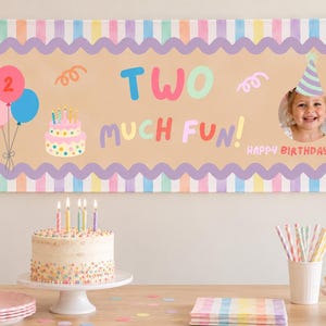 May include: A rectangular birthday banner with a tan center, a purple scalloped border, and pastel striped edges. It features the text TWO MUCH FUN, a cake illustration, balloons, confetti, and a circular photo frame of a child wearing a party hat.