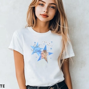 May include: A white short-sleeved t-shirt featuring a blue star graphic with the text "Silent Treatment" and "FREYA SKYE" printed on the front. The design includes a small photographic portrait of a person and several smaller blue star icons.