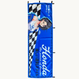 May include: A rectangular blue banner featuring a black and white checkered pattern on the left side. It displays an anime-style character wearing a white Honda top, the text Honda the power of dreams, and Japanese characters along the edges.